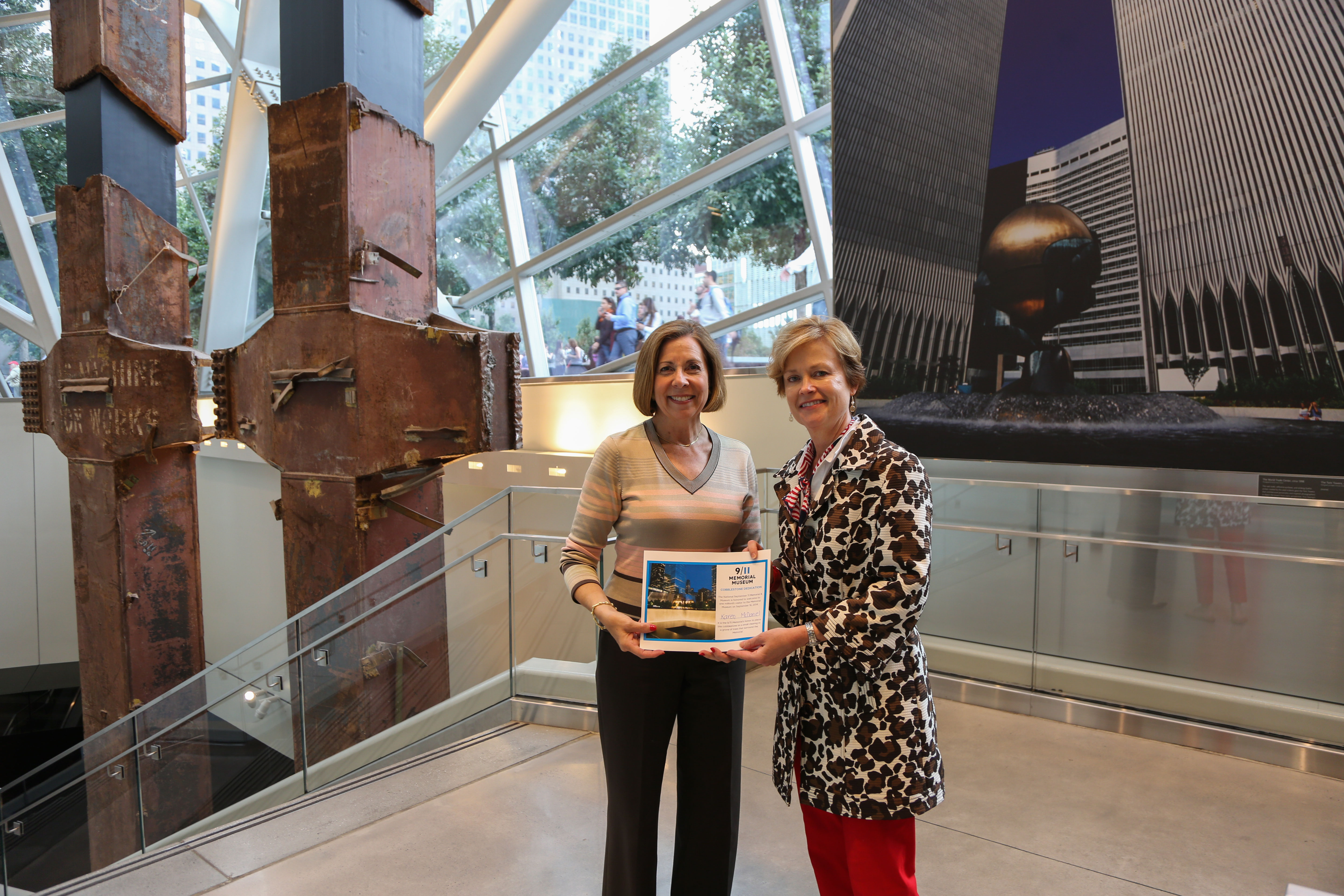 Karen McDaniel, the Museum’s one millionth visitors, stands with 9/11 Memorial Museum Director Alice Greenwald beside the tridents at the Museum.