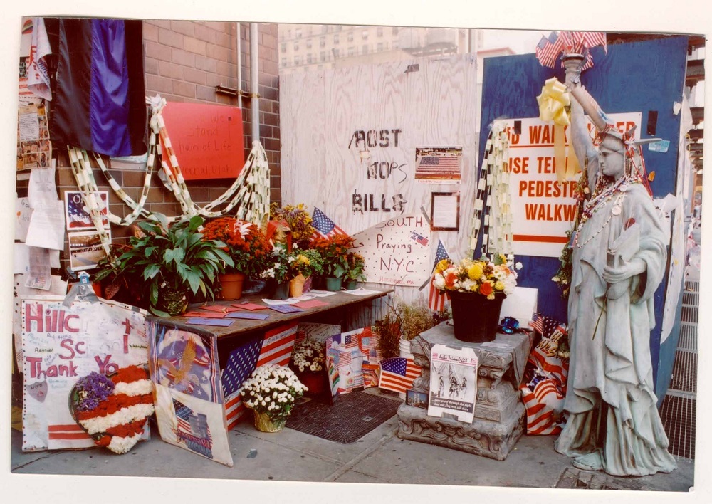 The Lady Liberty statue stands outside Battalion 9 firehouse in September 2001. Dozens of other tributes, including American flags and flowers, have been placed in an area beside the statue.