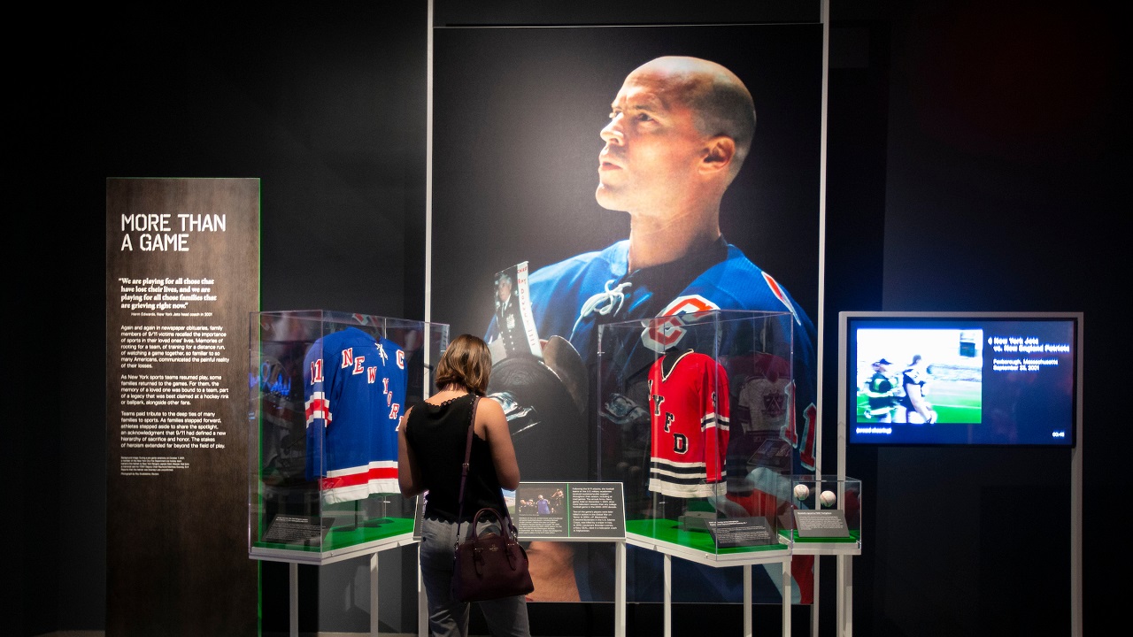 A large photograph of Rangers Captain Mark Messier appears beside two jerseys in the exhibition "Comeback Season: Sports After 9/11."