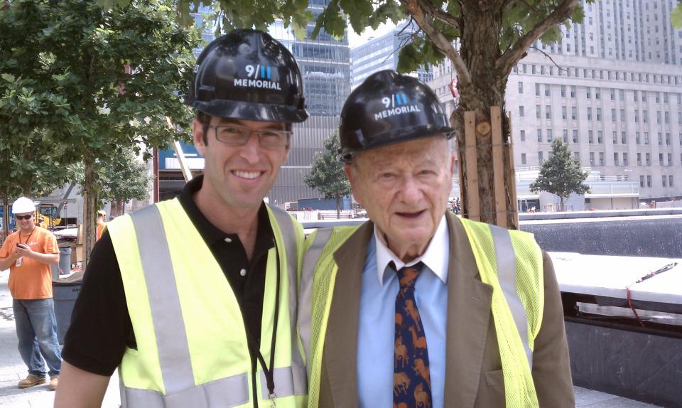 9/11 Memorial architect Michael Arab and former New York City Mayor Ed Koch smile for a photo on Memorial plaza. They are both wearing 9/11 Memorial hardhats.