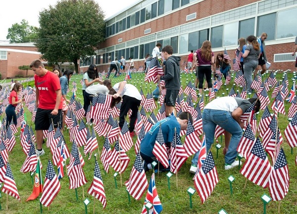 To commemorate 9/11, Cedar Grove High School students install nearly 3,000 American flags on the front lawn of the high school.