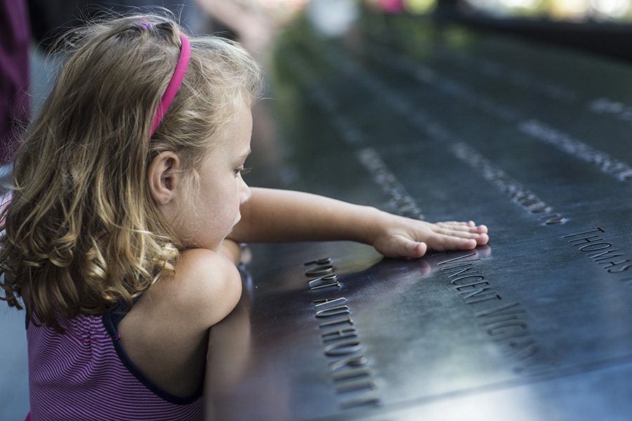 A child rests their hand on the 9/11 Memorial parapets during a recent Youth and Family tour. Photo by Jin Lee.