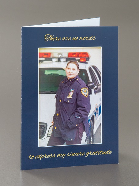 Card with a photograph of Diane DiGiacomo in uniform on the front with printed text "There are no words | to express my sincere gratitude." Collection 9/11 Memorial Museum, gift of the Diane DiGiacomo family. Photo by Michael Hnatov.