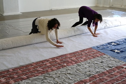 Valerie Soll and Lisa Kelman rolling the flag onto a soft tube. Photo by Maureen Merrigan.