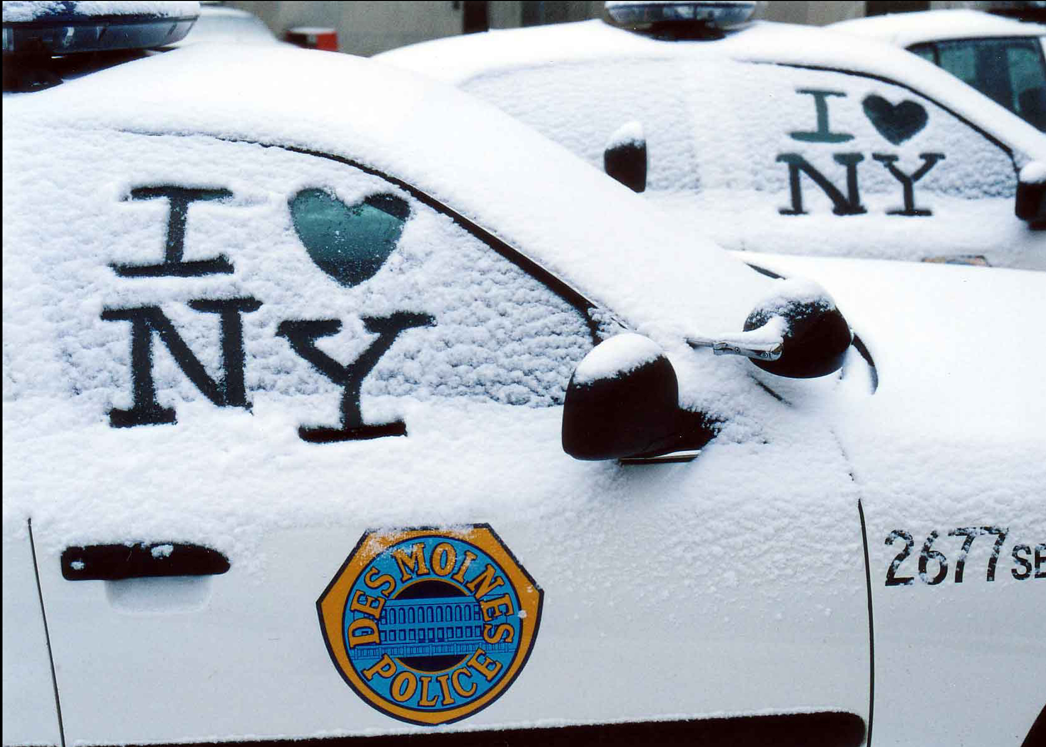 "I love NY" in snow on a Des Moines Police Car.