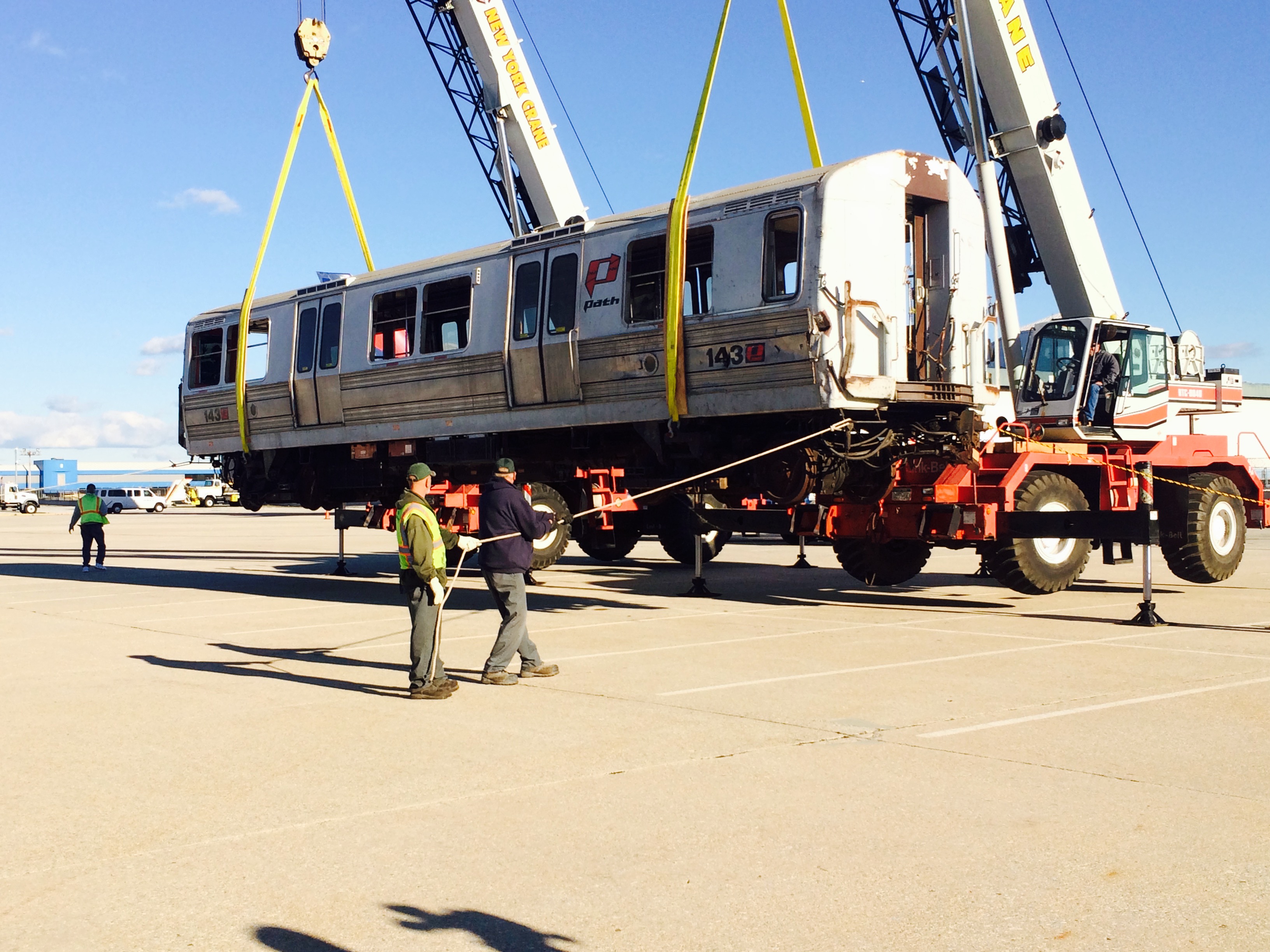 Crews load PATH train car number 143 onto a flatbed trailer outside Hangar 17 at John F. Kennedy International Airport.