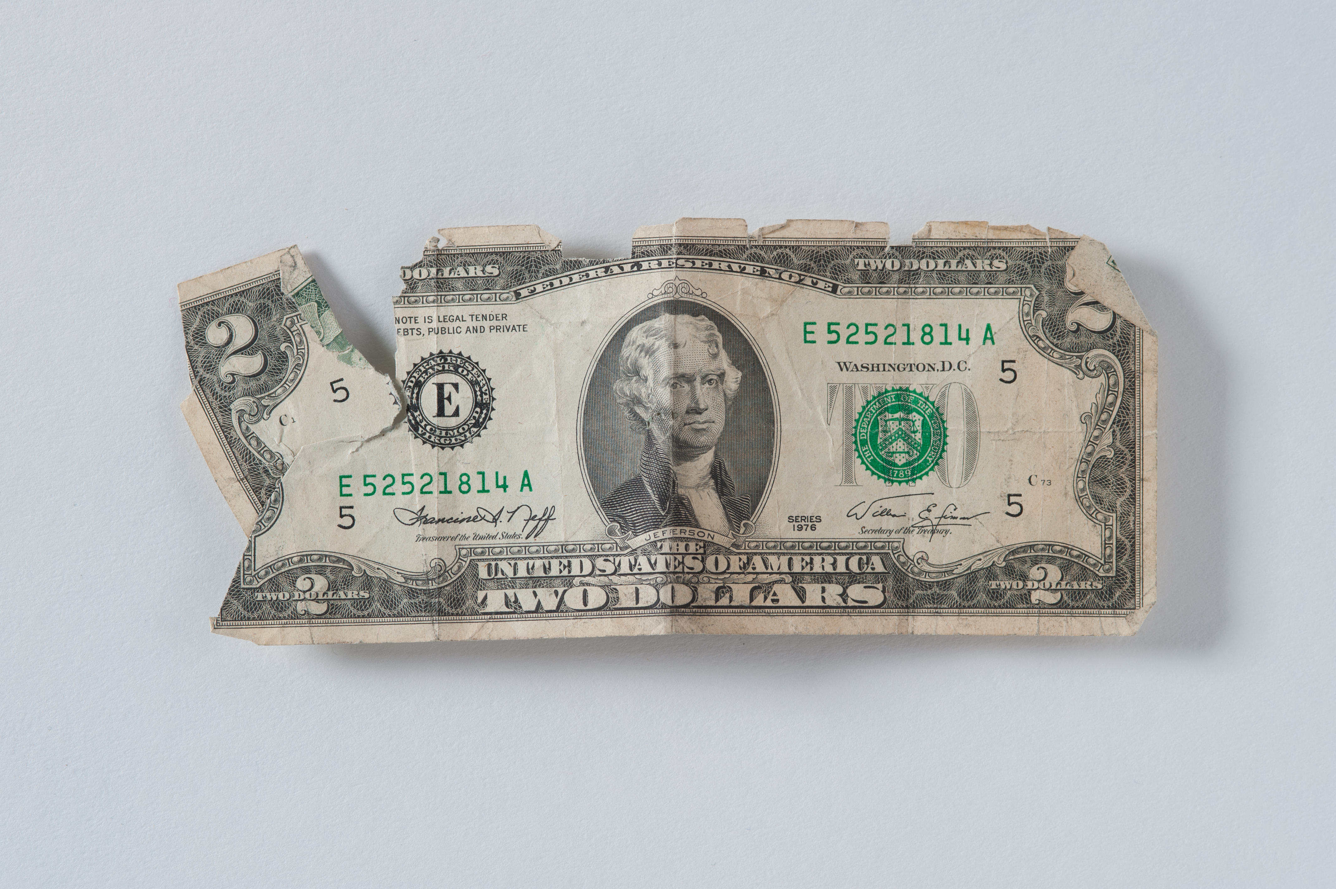 A worn $2 bill belonging to Robert Gschaar is displayed on a white surface. The bill was found inside Gschaar’s wallet at Ground Zero.