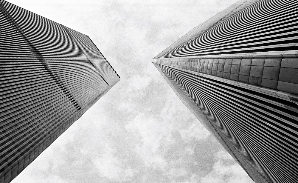 This black-and-white towers from the World Trade Center plaza show the Twin Towers rising to the sky.