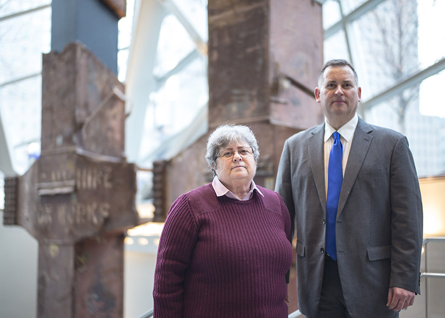 Vincent Boneski and Myrna Weinstein stand in front of the steel tridents at the entrance to the Museum.