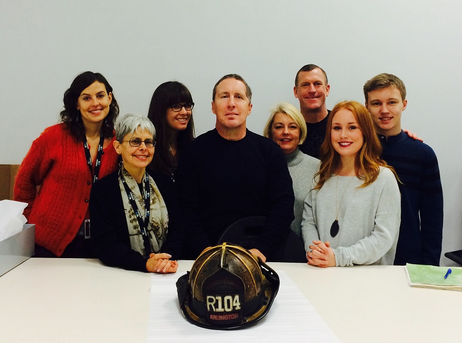 Retired Arlington County Fire Chief Robert Gray, members of his family, and curators from the Museum pose next to Gray’s fire helmet, which Gray donated to the Museum.