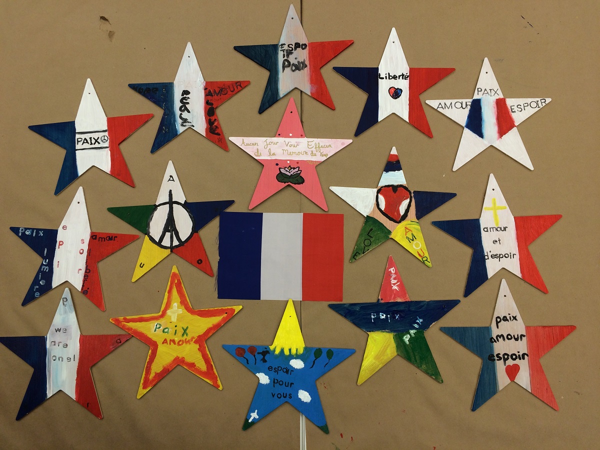 Stars of hope created by visitors to the 9/11 Memorial Museum Education Center hang on the wall. The stars support Paris, France, after a terrorist attack in the city. Many of the stars are colored in the pattern of the French flag.