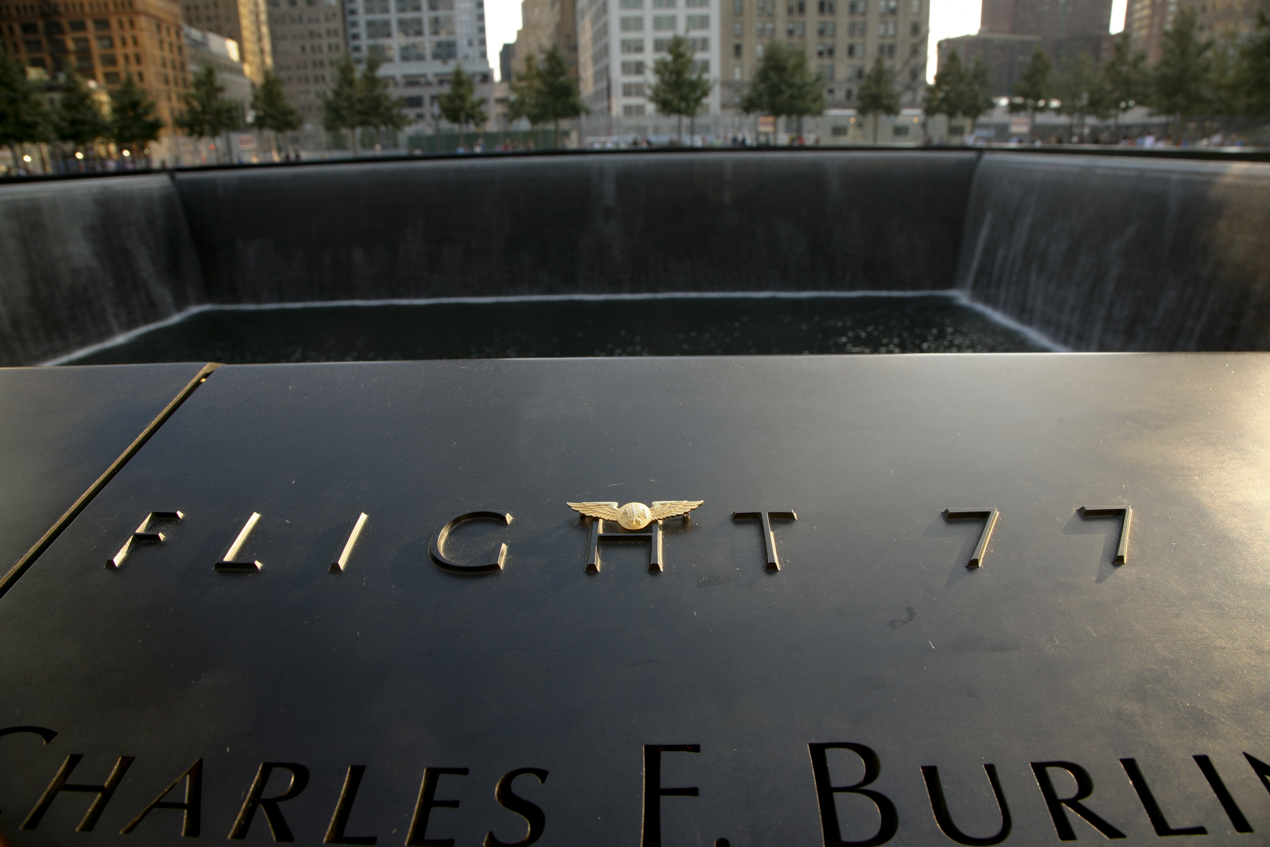 Pilot wings have been placed at the section of the 9/11 Memorial paying tribute to the victims of Flight 77. The reflecting pool is in the background.