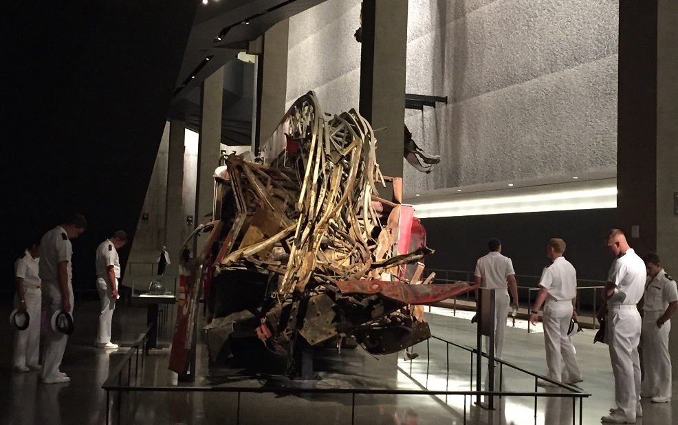 Members of the U.S. Navy look at the destroyed fire engine, Ladder 3, at the 9/11 Memorial Museum.