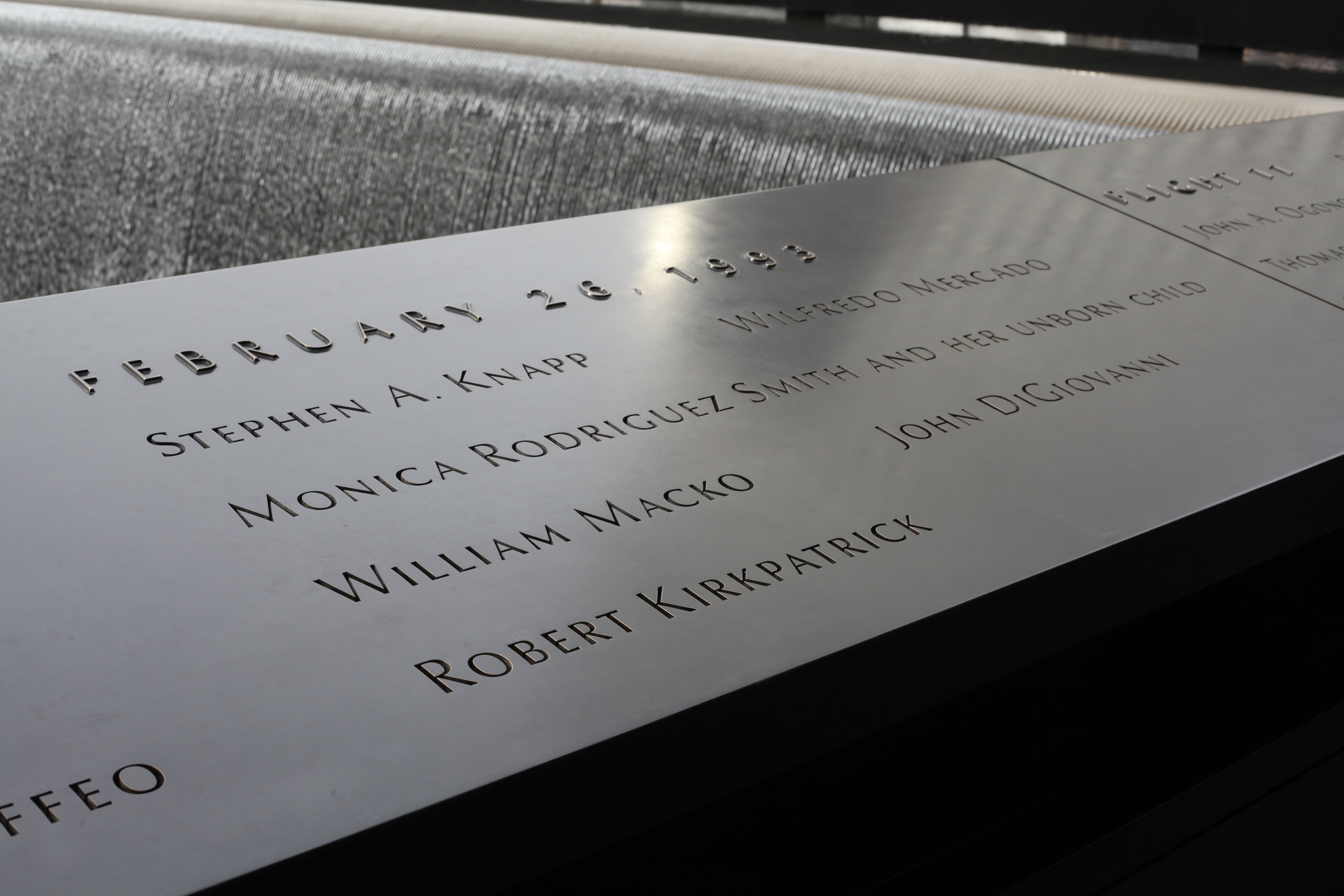 The names of the six victims of the 1993 bombing are seen on a bronze parapet beside a reflecting pool on the 9/11 Memorial.
