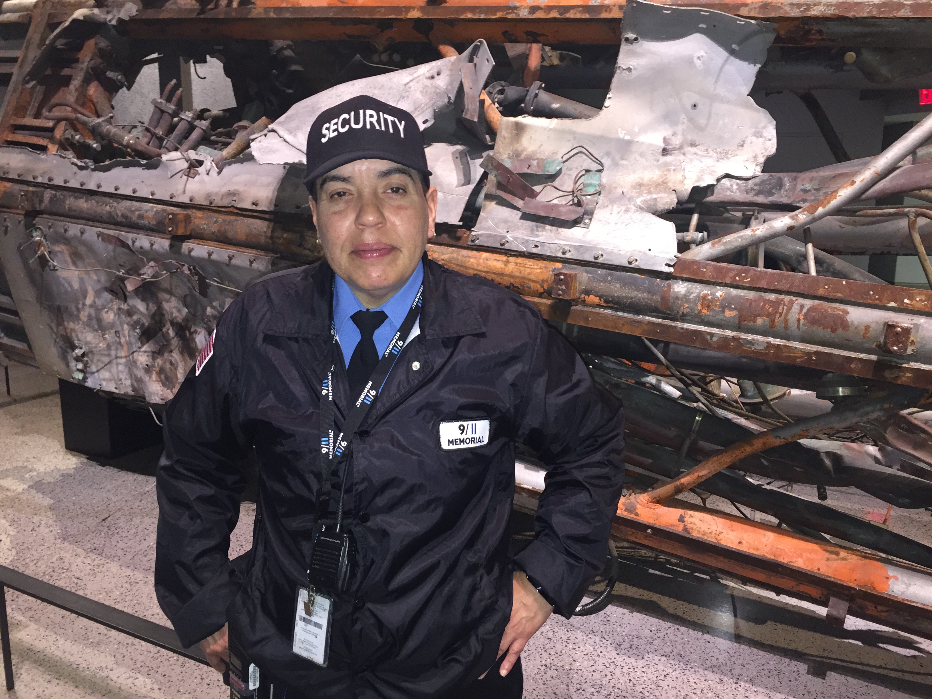 9/11 Memorial Museum security guard Mary Santos stands in front of a destroyed radio and television antenna from the North Tower.