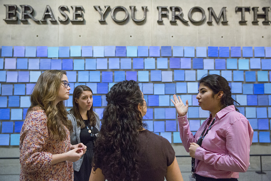 A young woman practices giving a tour in front of artist Spencer Finch’s installation, “Trying to Remember the Color of the Sky on That September Morning,” in the 9/11 Memorial Museum. Three women watch her as she practices the tour.