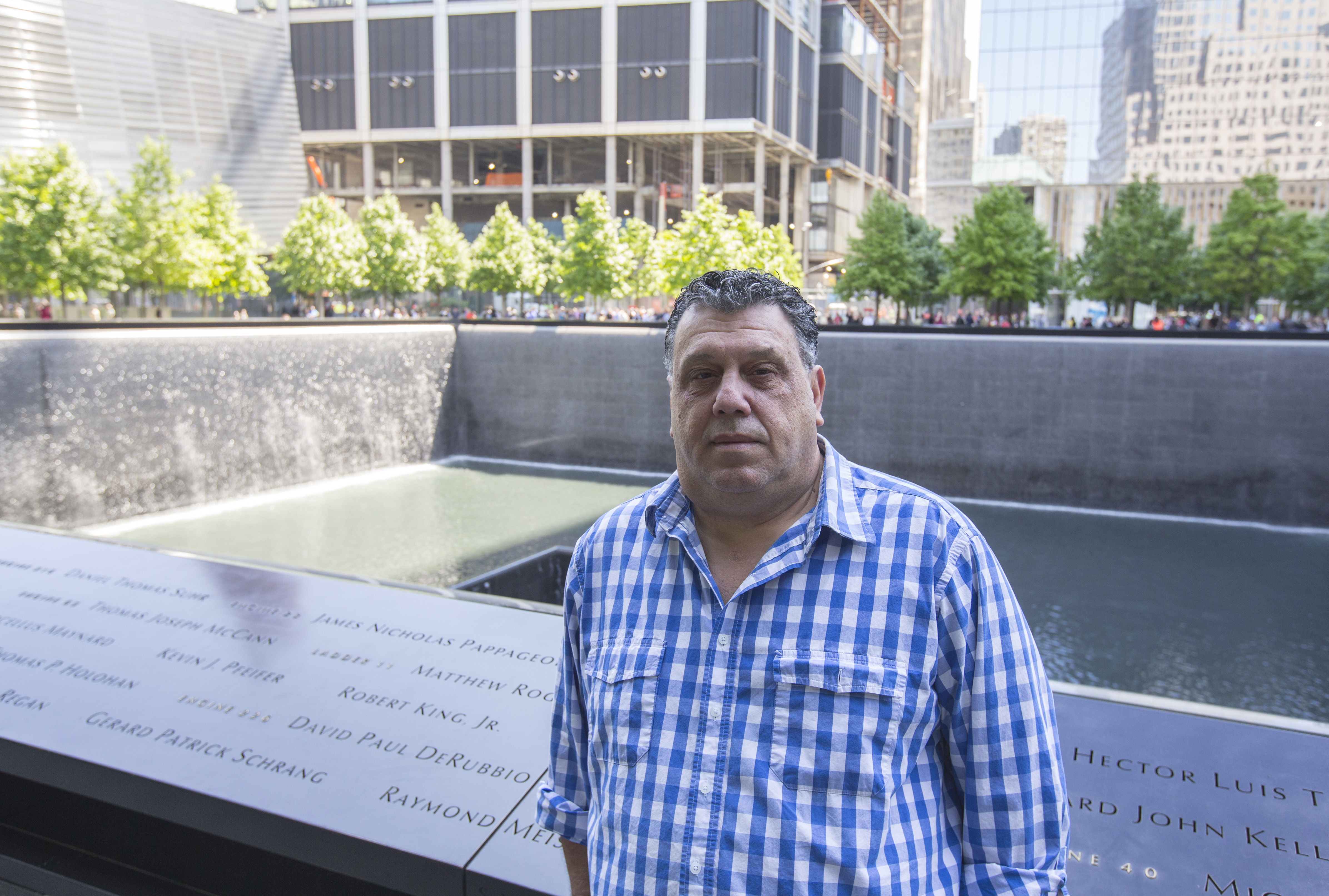Lou Mendez, the vice president of facilities at the 9/11 Memorial, stands for a photo beside the south pool.