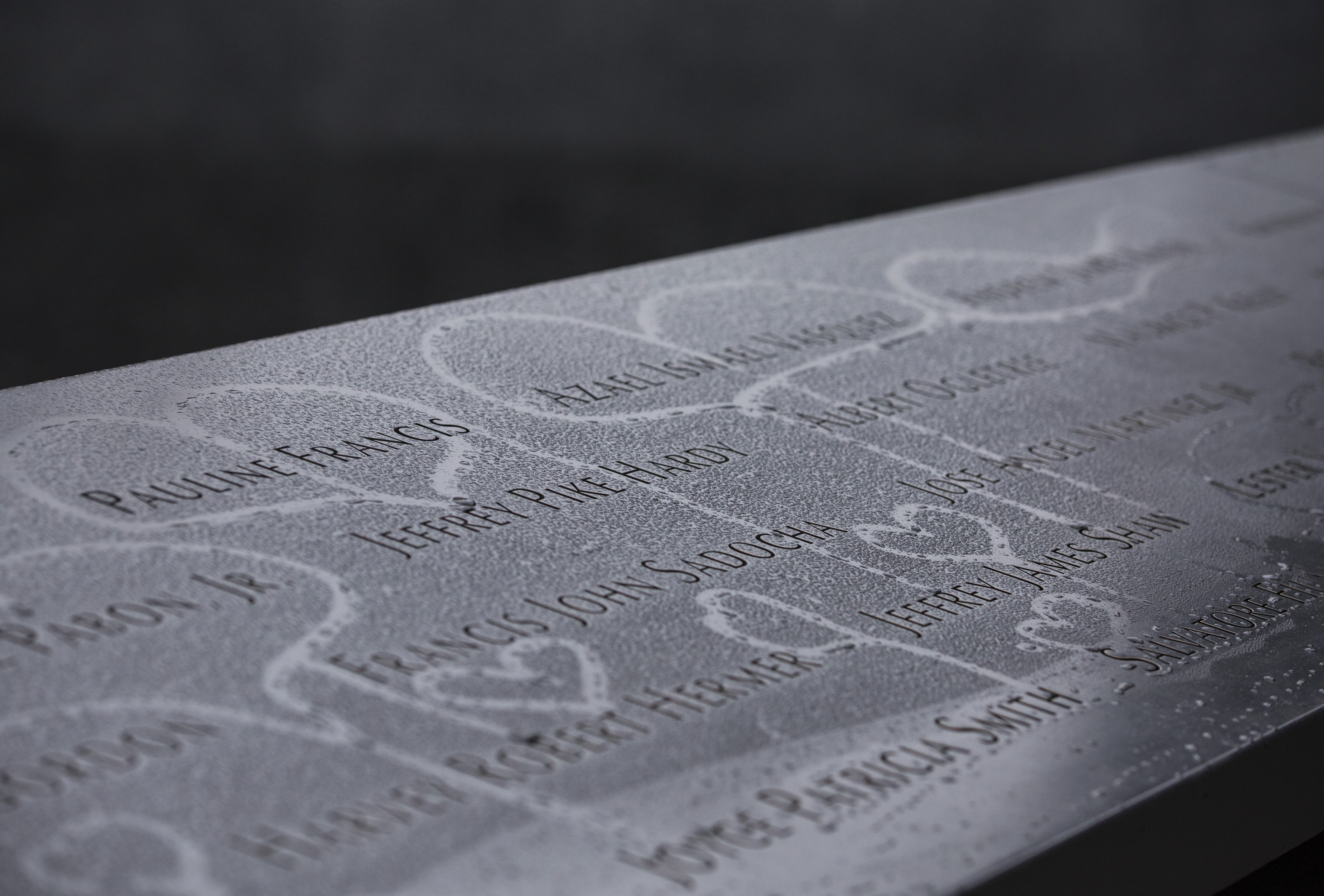 Hearts have been drawn in condensation that formed on names at the 9/11 Memorial.