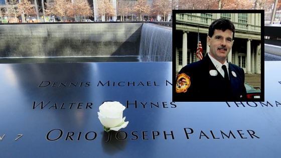 A white rose has been placed at the name of FDNY Battalion Chief Orio Palmer on the Memorial. An inset features an old image of Palmer smiling in his formal uniform.