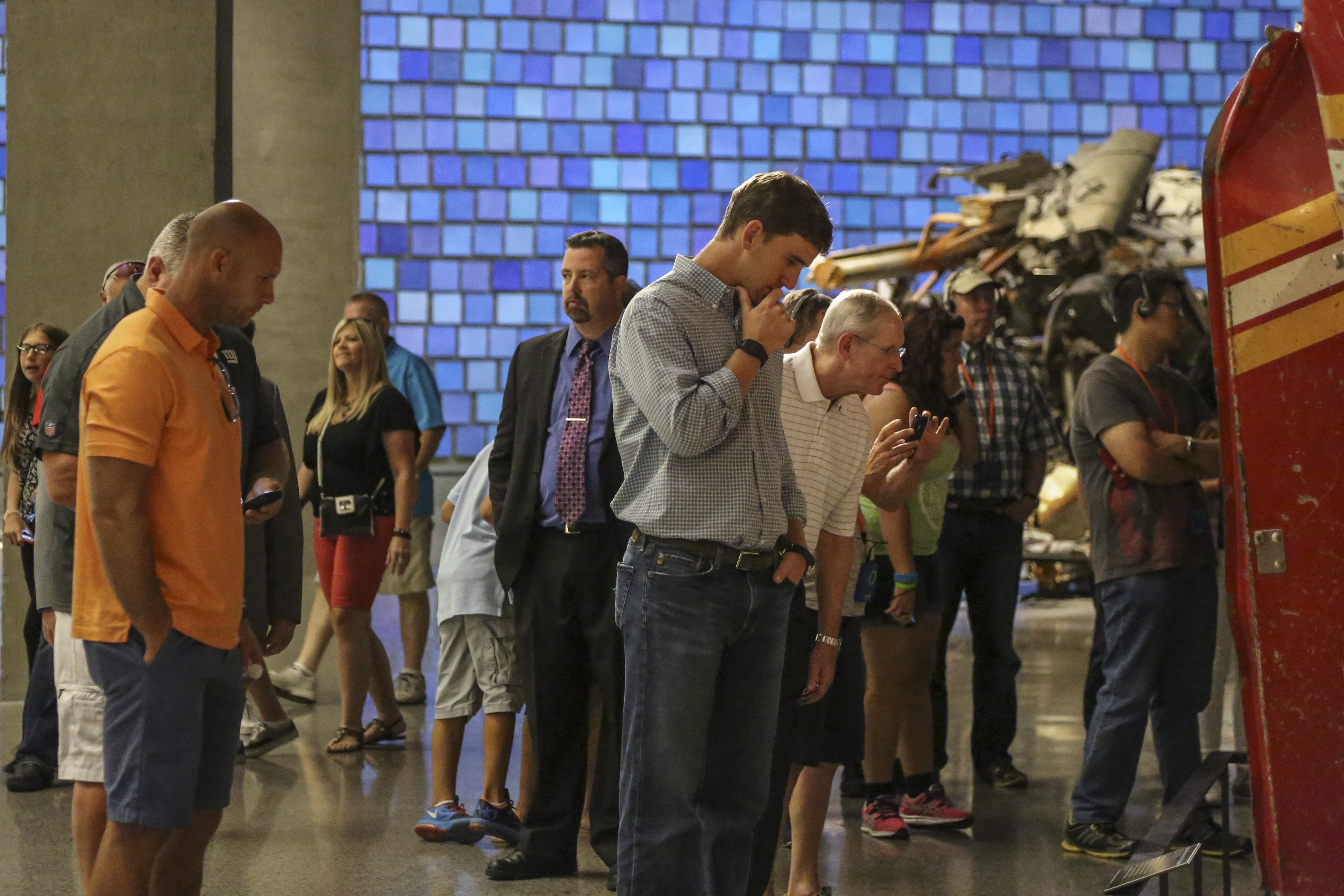 Eli Manning and New York Giants coach Tom Coughlin observe Ladder 3 at the Museum. A crowd of other visitors are in the background.