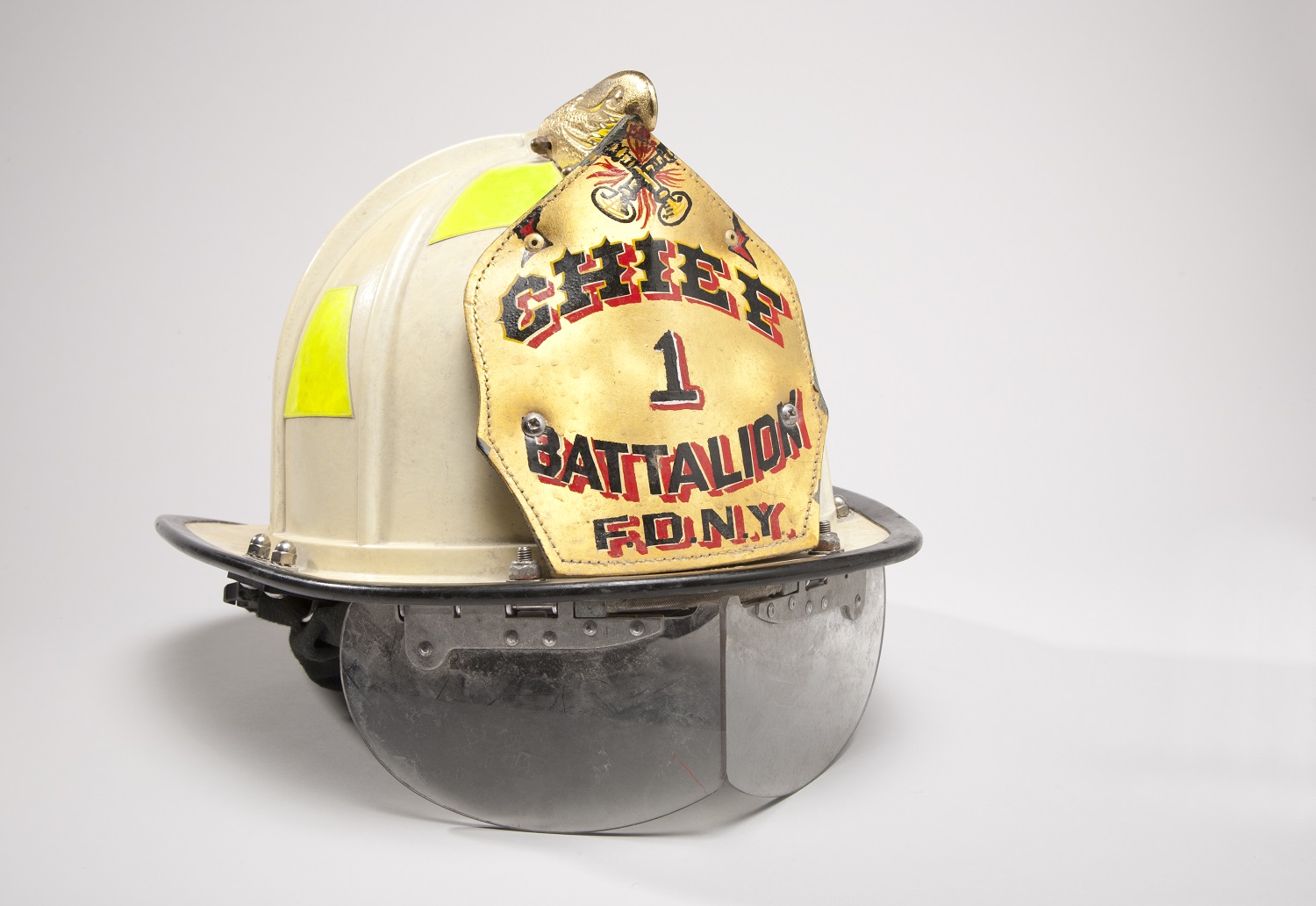 Chief Joseph Pfeifer’s golf-colored fire helmet is displayed on a white surface.