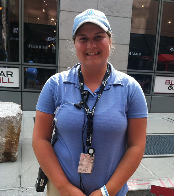 Visitor services host Samantha Rooney smiles for a photo near 9/11 Memorial plaza on a sunny day.