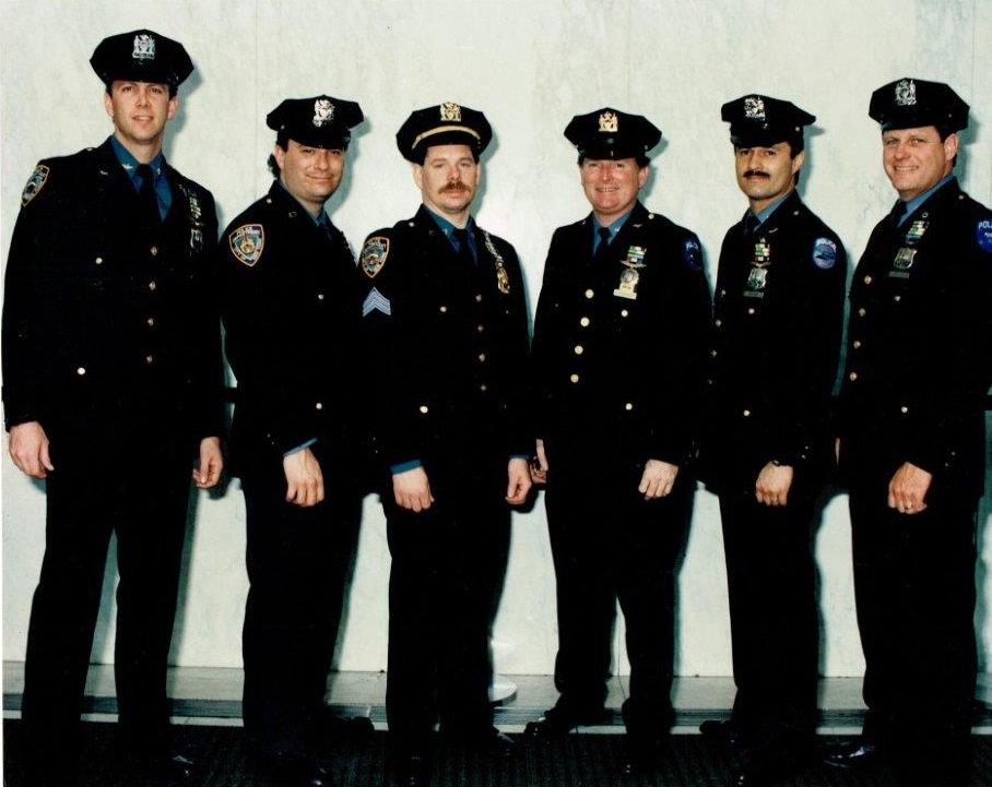 NYPD members Thomas Defresco, Joseph Zogbi, Timothy Farrell, Gregory Semendinger, Richard Troche and Robert Schierenback pose for a photo in their uniforms.