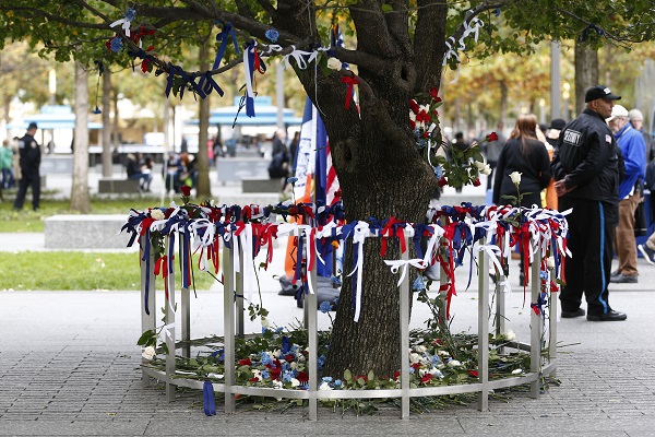 Red, white, and blue flowers and ribbons encircle the Survivor Tree as a tribute to the victims of a bicycle path attack in lower Manhattan.