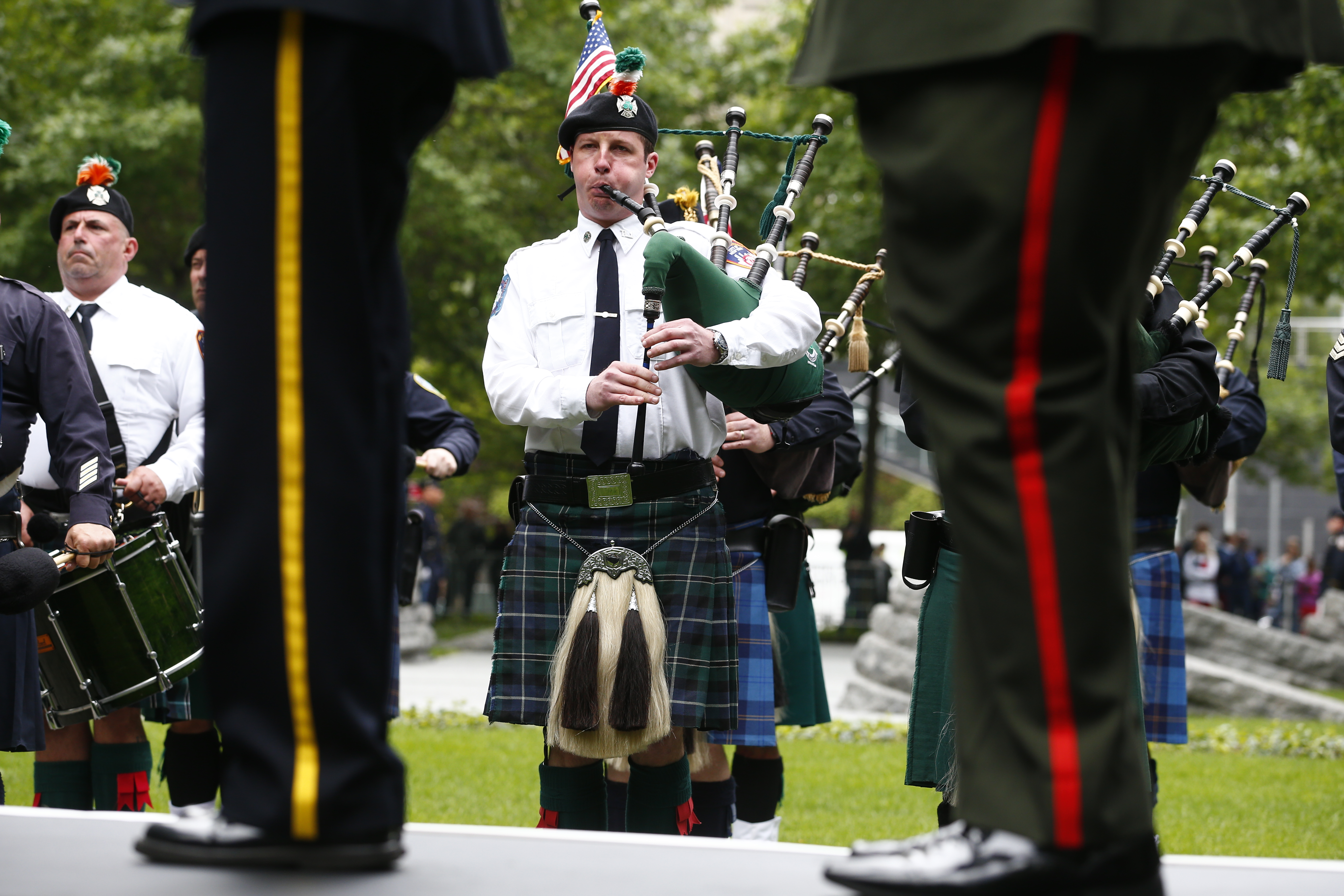 Men in kilts play bagpipes and bass drums on the Memorial plaza.