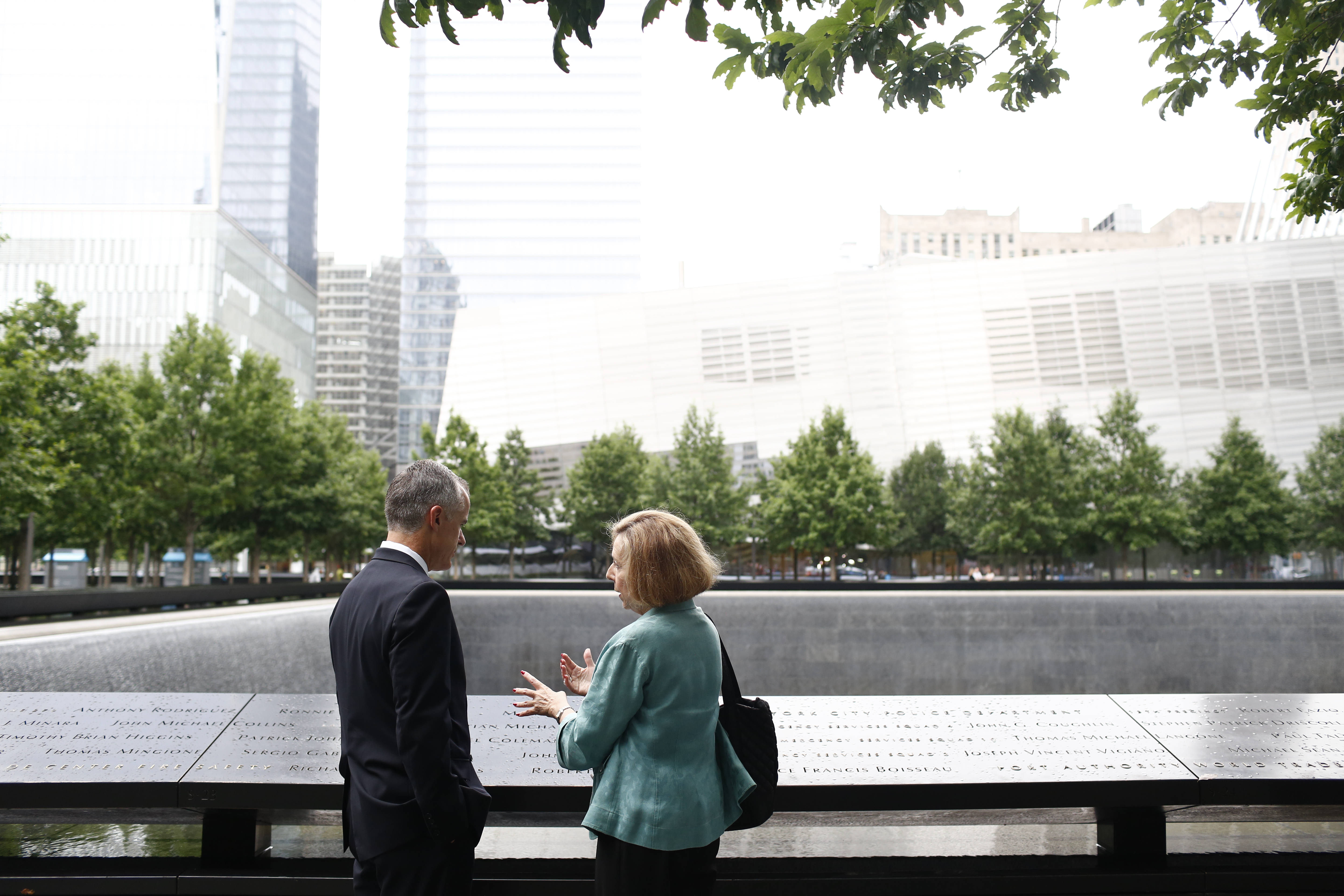 FBI Deputy Director Andrew McCabe and 9/11 Memorial Museum Director Alice Greenwald speak beside a reflecting pool at the 9/11 Memorial.