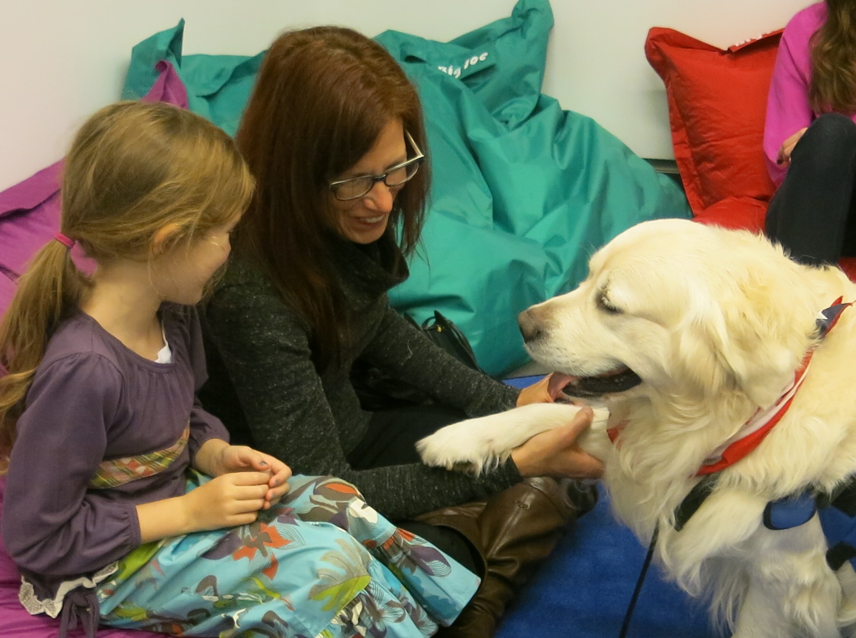 Chance, a trained disaster relief canine, interacts with a young girl and a woman in the Museum’s Education Center.