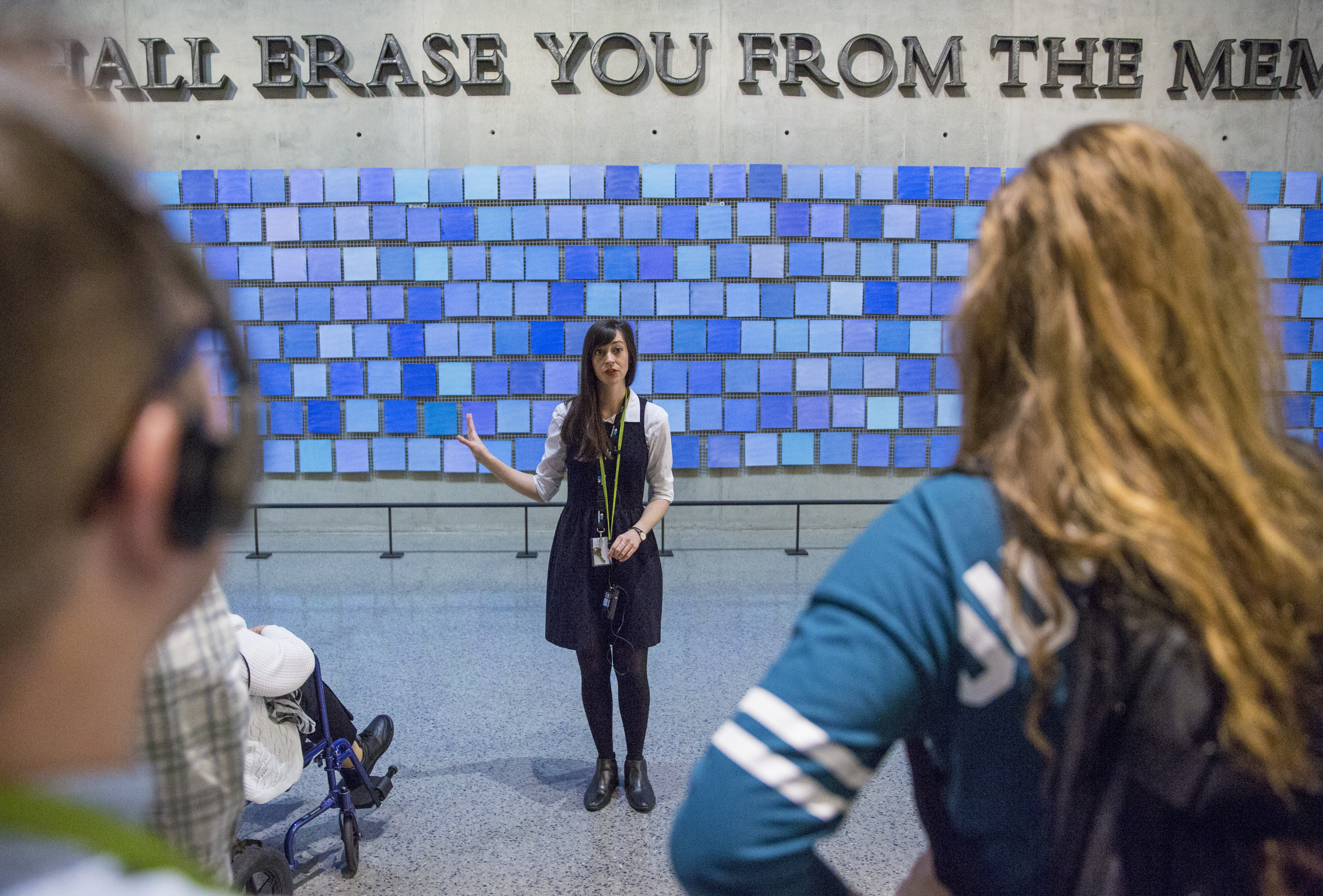 Several visitors watch as an interpretative guide stands in front of artist Spencer Finch’s installation, “Trying to Remember the Color of the Sky on That September Morning,” leading a tour in the 9/11 Memorial Museum.