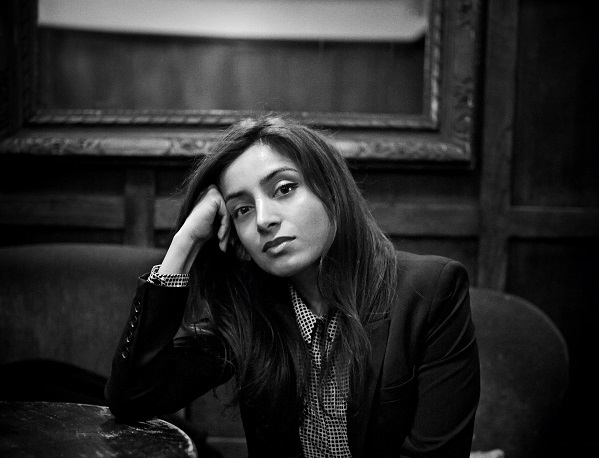 Filmmaker and activist Deeyah Khan poses while sitted for a black and white photo.