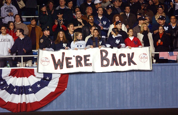 Yankees fans hold a sign reading “We’re Back” as they sit in the stands during a World Series game after 9/11.