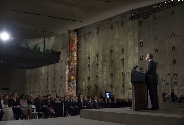 President Barack Obama addresses a crowd of people from a podium in Foundation Hall as part of a dedication ceremony for the 9/11 Memorial Museum.