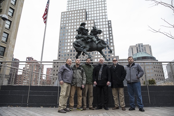 Six men known as the “horse soldiers” are seen in front of “De Oppresso Liber,” an 18-foot bronze statue depicting a Green Beret soldier on horseback at Liberty Park near the Memorial.