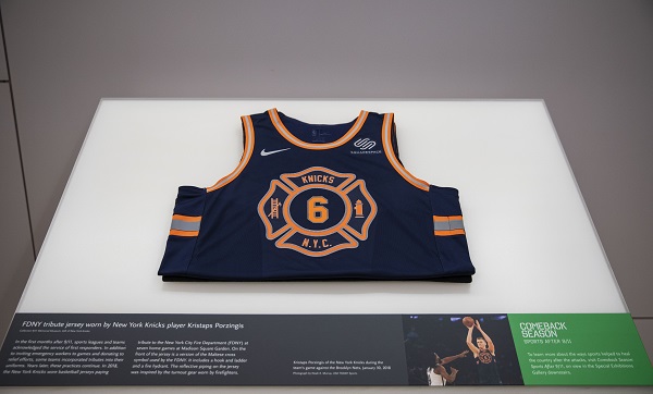 A blue and yellow FDNY tribute jersey worn by former New York Knicks player Kristaps Porzingis is displayed at the Museum.