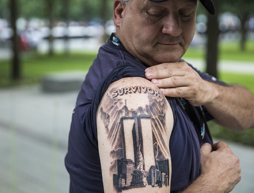 Tom Canavan shows off a new tattoo on his right arm. It depicts the Twin Towers along with the word “Survivor.”