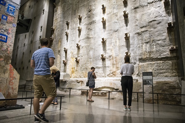 Four visitors—three women and a man—observe the slurry wall and the Last Column at the Museum.