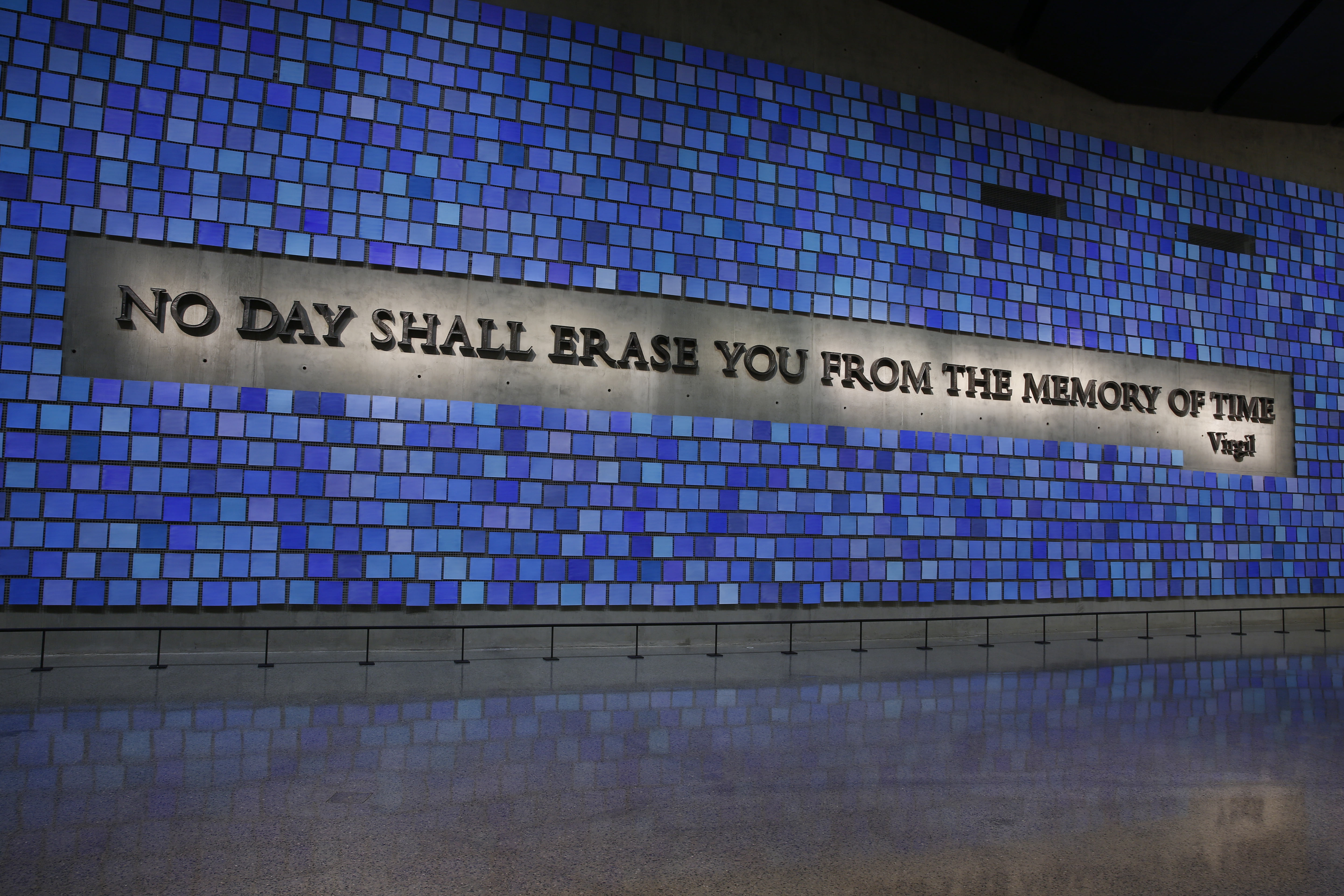 Artist Spencer Finch’s art installation “Trying to Remember the Color of the Sky on That September Morning” is seen illuminated at the 9/11 Memorial. It features Virgil quote “No day shall erase you from the memory of time.”
