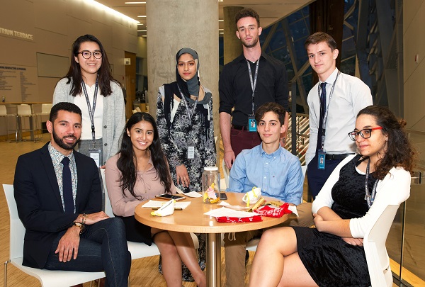 Four young men and four young women who are Museum ambassadors pose for a photo at the Museum Cafe.