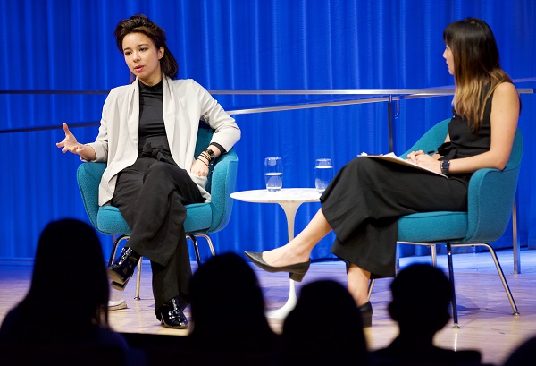 VICE correspondent Isobel Yeung speaks onstage at the 9/11 Memorial Museum as part of a public program. Jessica Chen, the director of public programs at the Museum, sits in a chair beside her.