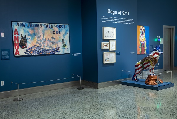 The exhibition “Dogs of 9/11” is seen at the Museum. It includes artwork of dogs and a statue of a dog in the colors of the American flag.
