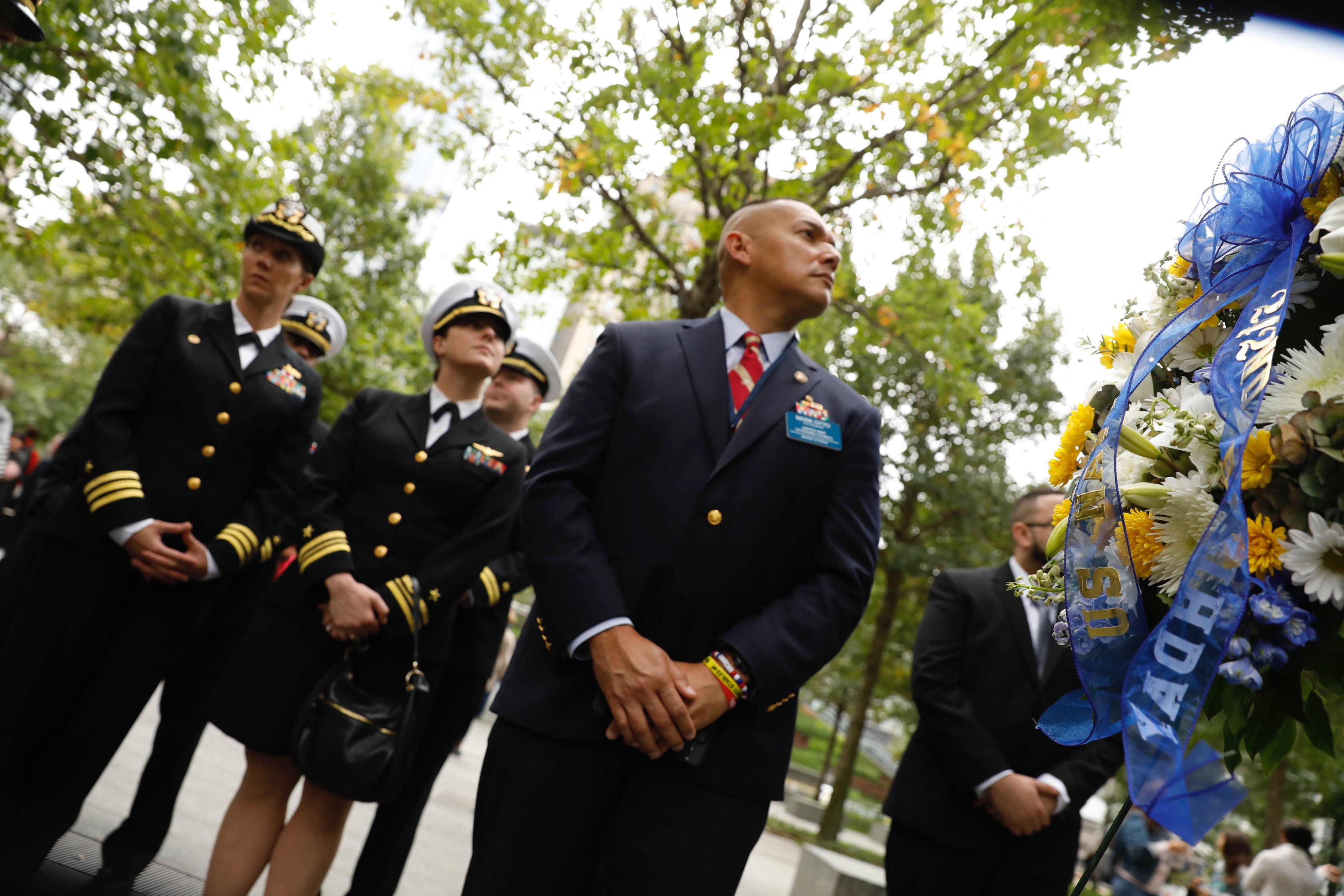 U.S. Naval officers and veterans stand at the Memorial plaza.