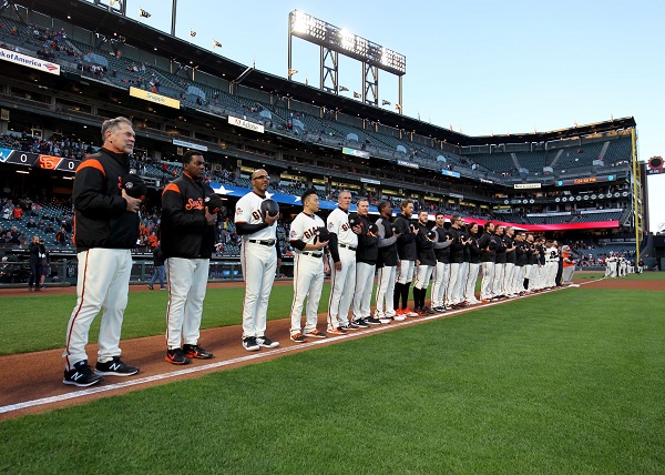 San Francisco Giants players hold their hats to their hearts as they pay tribute to those killed in the 9/11 attacks during a pre-game ceremony in AT&T Park.