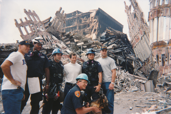 In this photo from September 16, 2001, New York Rangers players Mark Messier, Mike Richter, and Eric Lindros, as well as Rangers executives, visit rescue workers at Ground Zero. The men pose for a photo with piles of debris and remnants of the Twin Towers behind them.