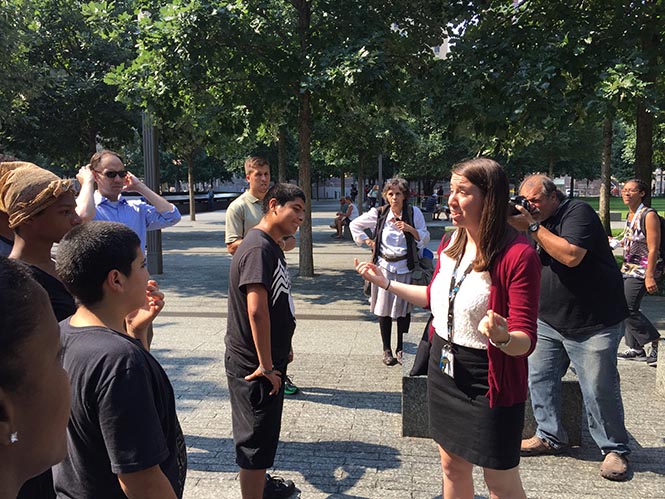 Education specialist Shannon Elliott leads a group of students on Memorial plaza.