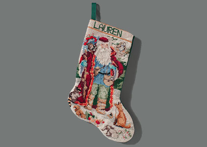 A holiday stocking belonging to Flight 93 victim Lauren Catuzzi Grandcolas is displayed on a gray surface at the Museum. Santa Claus is on the stocking along with the name “Lauren.”