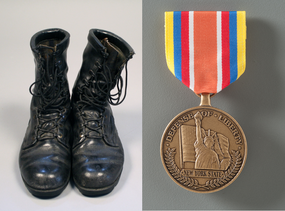 A composite image shows a pair of black leather combat boots. The boots are polished but well worn, and the leather is cracking in places. Next to the boots is a medal depicts an American flag and the Statue of Liberty with raised text: "DEFENSE OF LIBERTY | NEW YORK STATE." The medal is attached to a multicolored ribbon with a bar pin for affixing it to a uniform.