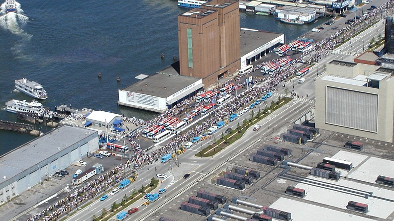 Aerial photograph of the West Midtown Ferry Terminal located at Piers 78 and 79 in Hudson River Park adjacent to the West Side Highway at West 39th Street in Midtown. Large crowds of people are boarding ferries to evacuate lower Manhattan, September 11, 2001.